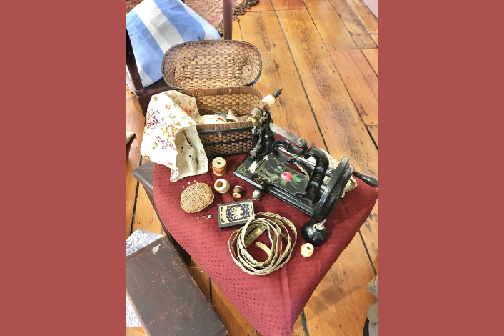 an open basket with antique items on a stool
