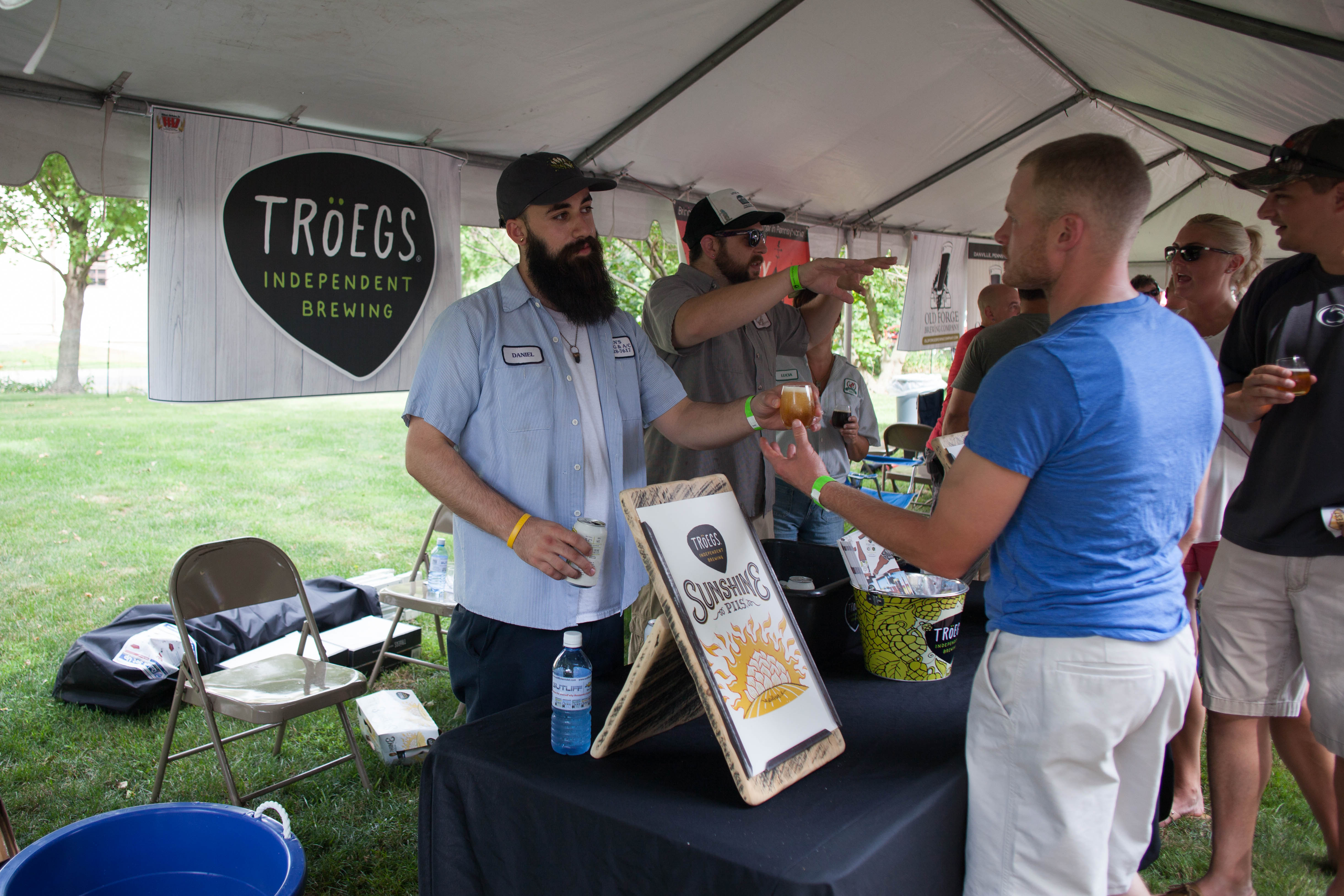 One man serving a beer sample to another man