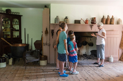 Family observing the mansion while tour guide speaks