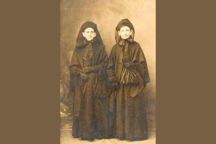 Two women in black Victorian era funeral dress