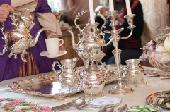 Costumed Attendant pouring tea from a silver teapot at an elegant table