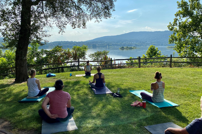 People doing yoga by the riverfront