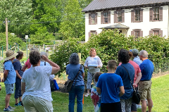 Woman speaking to a group next to a large garden
