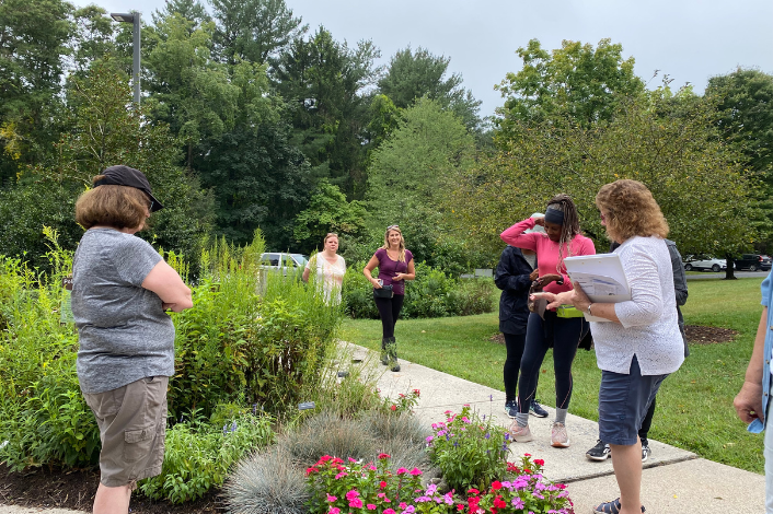 instructors and students admiring flowers