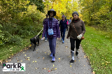 A group of people walking on a paved trail at Wildwood Park in jackets and hats