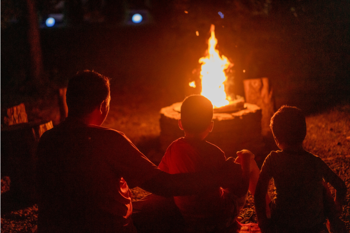 Families around a campfire roasting marshmallows