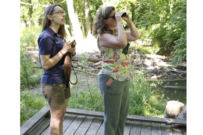 Two women outside with binoculars looking for birds