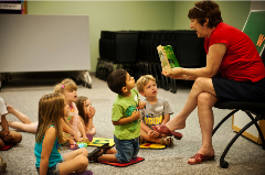 Adult educator reading to preschool kids